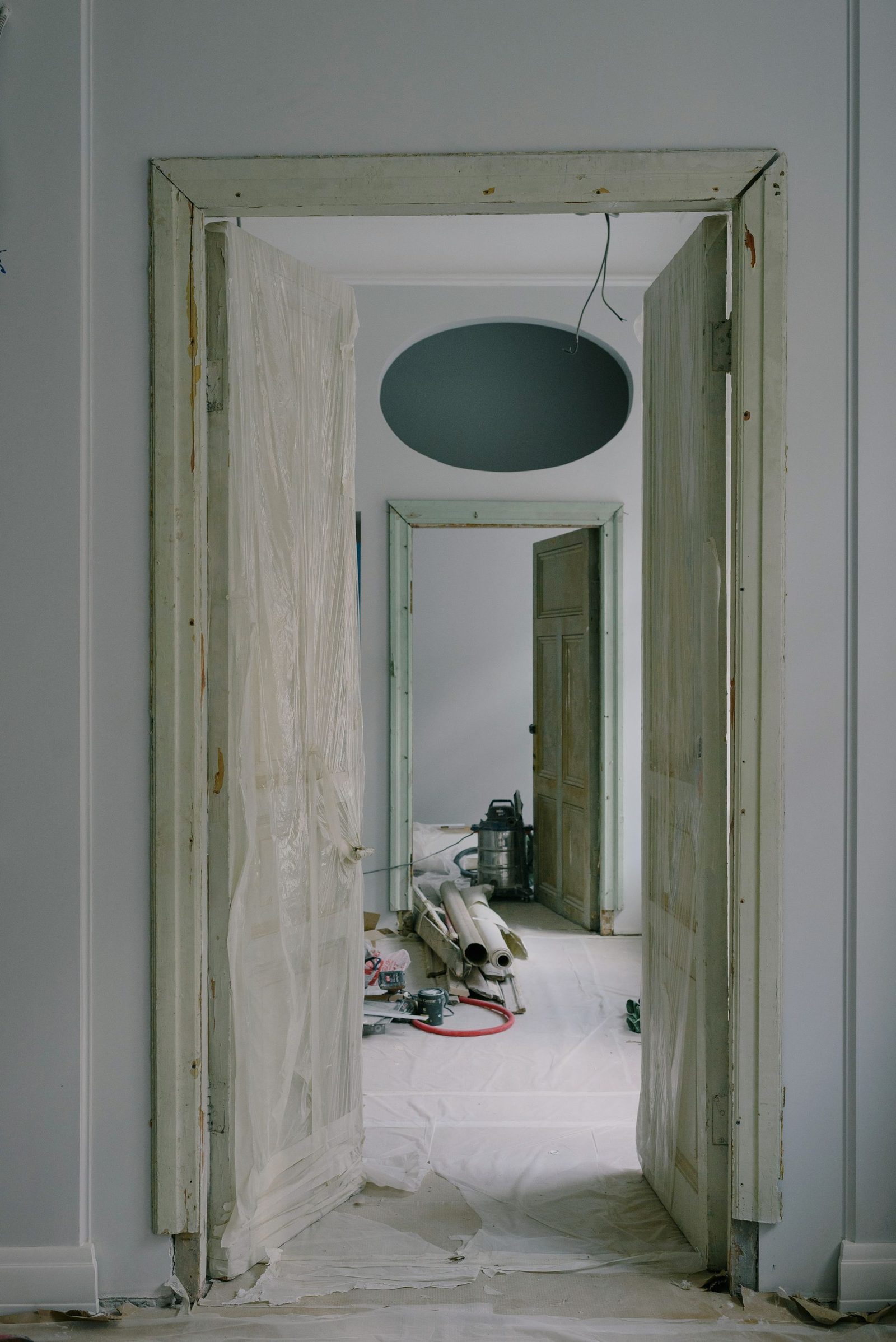 Room mid-renovation with dust sheets, materials and tools